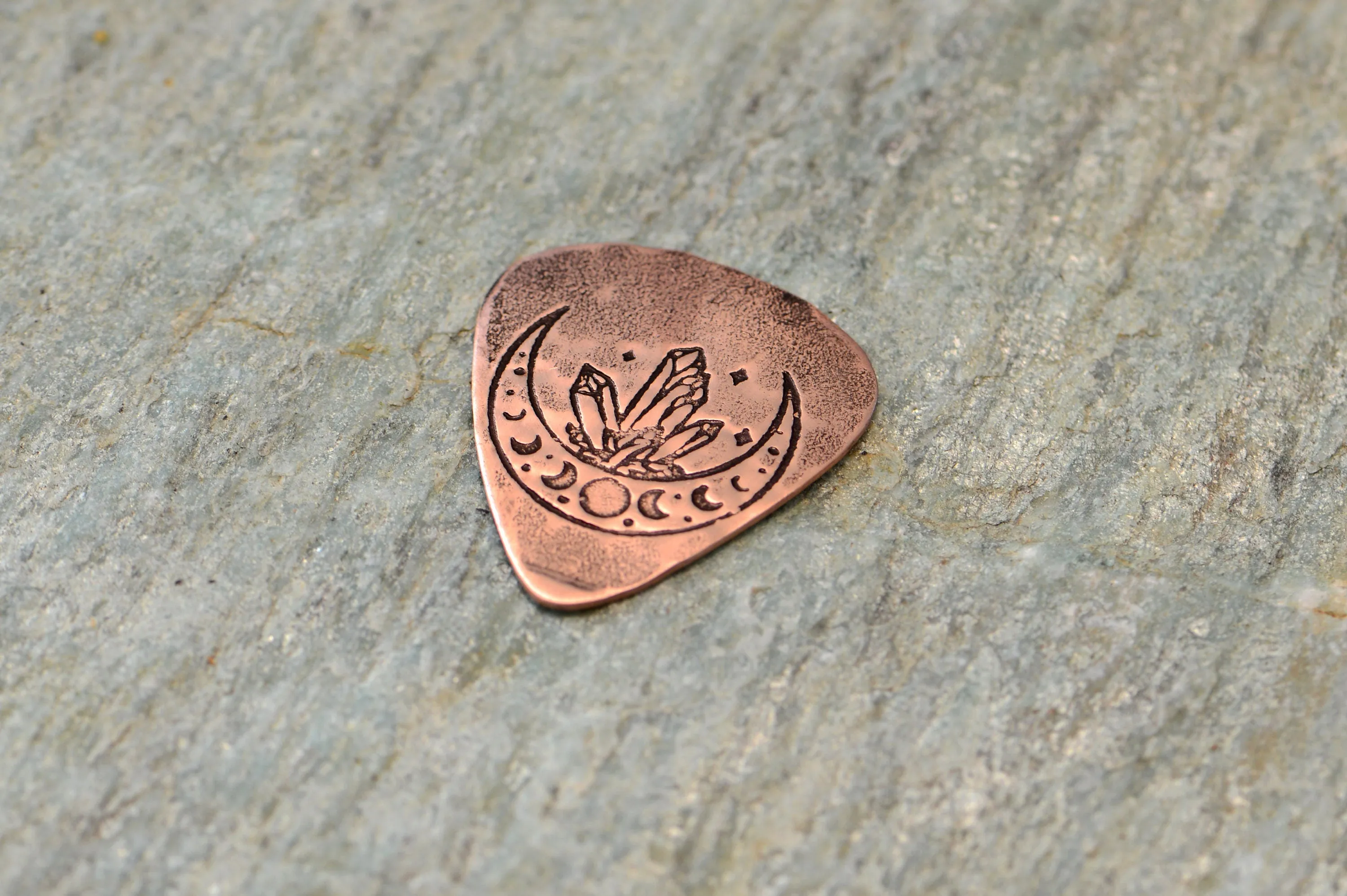 Copper guitar pick with crystal moon