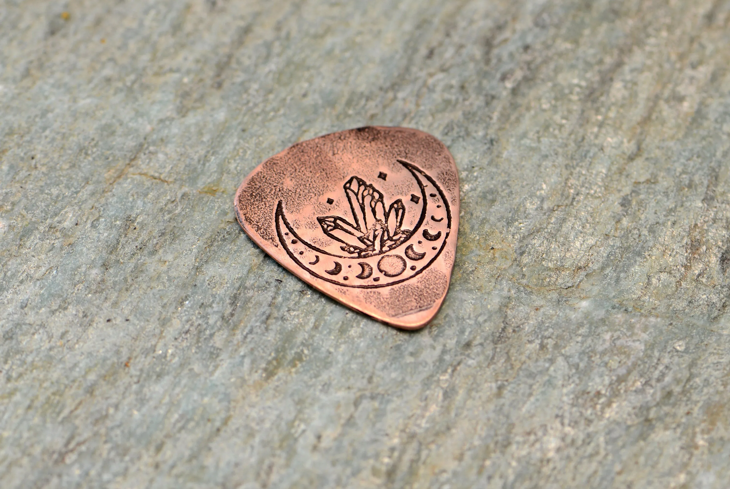 Copper guitar pick with crystal moon
