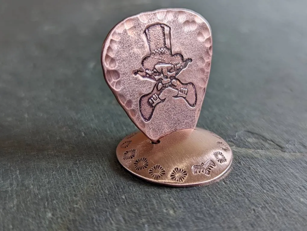 Copper guitar pick with skull and guitars theme