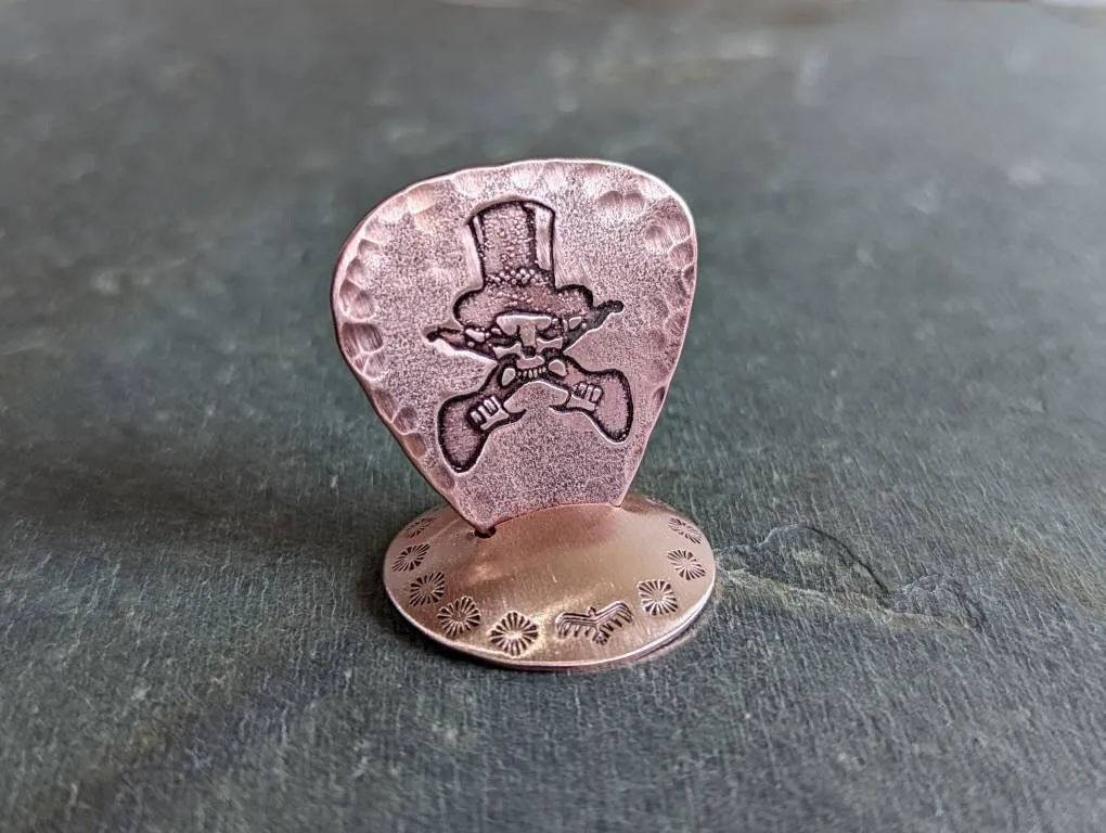 Copper guitar pick with skull and guitars theme