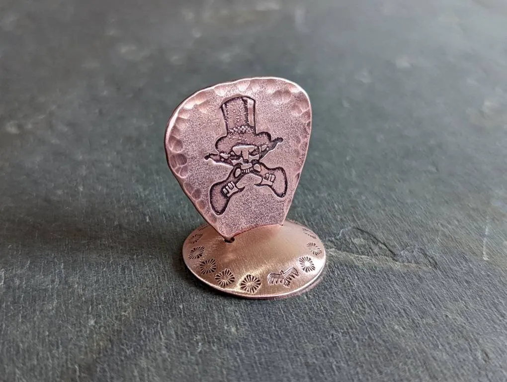 Copper guitar pick with skull and guitars theme