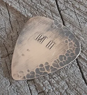 Distressed and rustic bronze guitar pick with tally mark